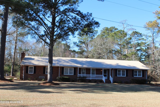 ranch-style home with covered porch and a front yard