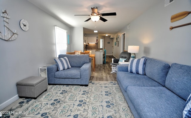 living room with light hardwood / wood-style flooring and ceiling fan