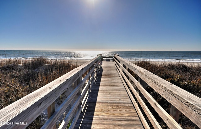 view of property's community with a water view and a view of the beach