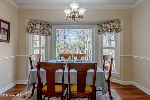 dining space featuring dark hardwood / wood-style flooring, crown molding, and a chandelier