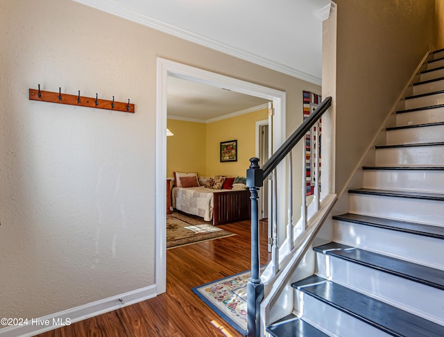 staircase featuring crown molding and wood-type flooring