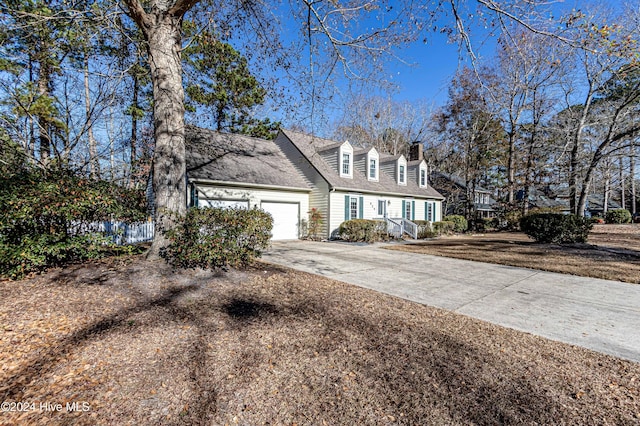 cape cod home with a garage