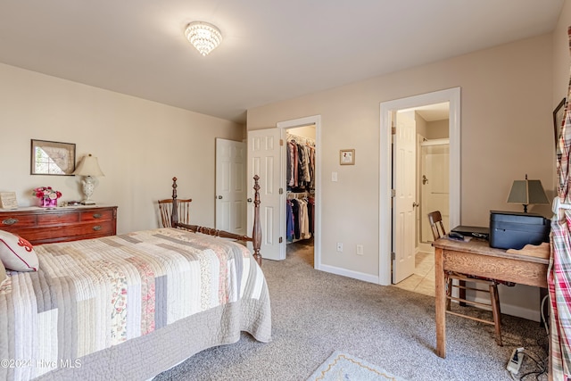 carpeted bedroom featuring ensuite bathroom, a spacious closet, and a closet