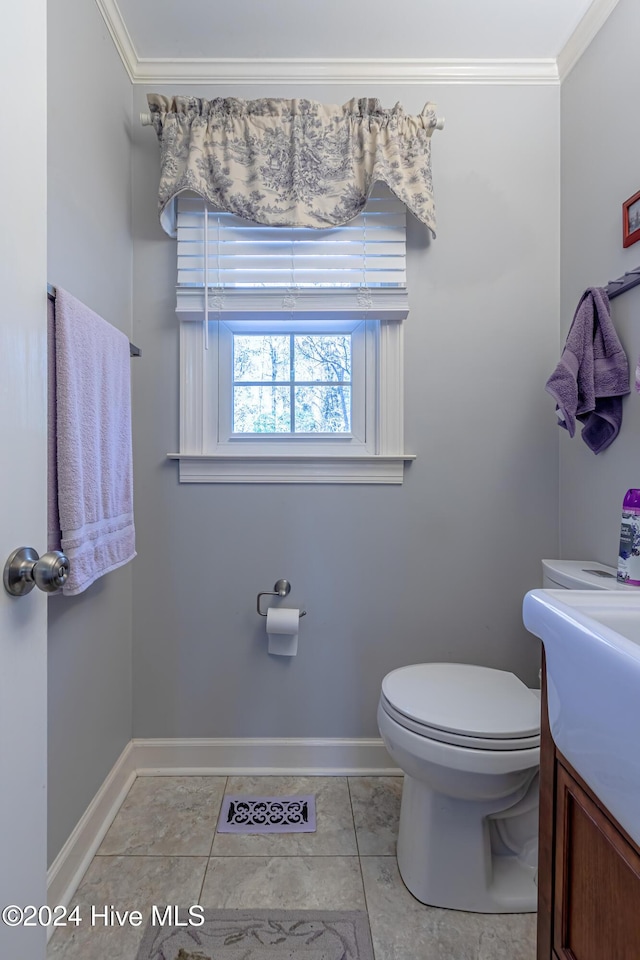 bathroom with tile patterned floors, vanity, toilet, and ornamental molding