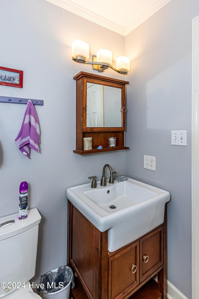 bathroom with vanity, toilet, and crown molding