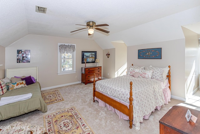 bedroom with a textured ceiling, ceiling fan, light carpet, and lofted ceiling