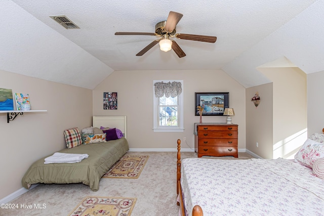 bedroom with carpet, a textured ceiling, vaulted ceiling, and ceiling fan