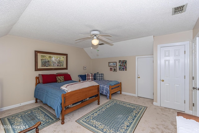 carpeted bedroom with vaulted ceiling, ceiling fan, and a textured ceiling