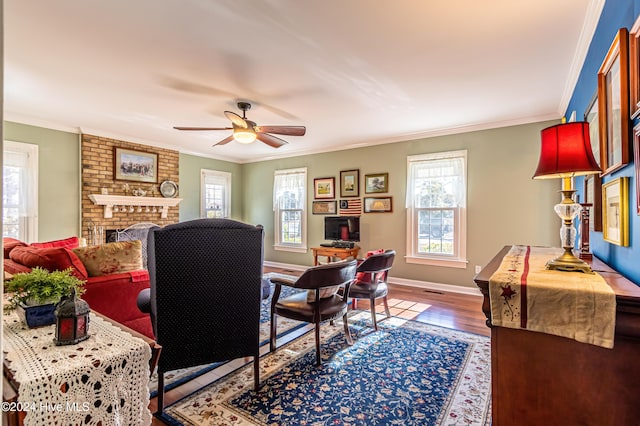 office featuring a fireplace, wood-type flooring, ceiling fan, and crown molding