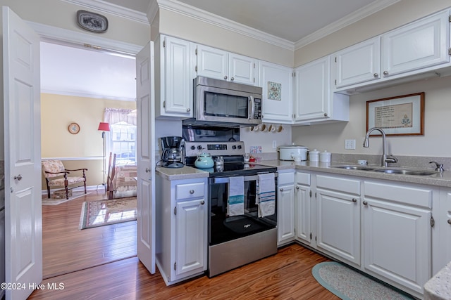 kitchen with white cabinets, hardwood / wood-style floors, stainless steel appliances, and sink