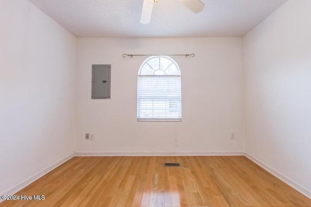 unfurnished room featuring electric panel, ceiling fan, and light hardwood / wood-style flooring