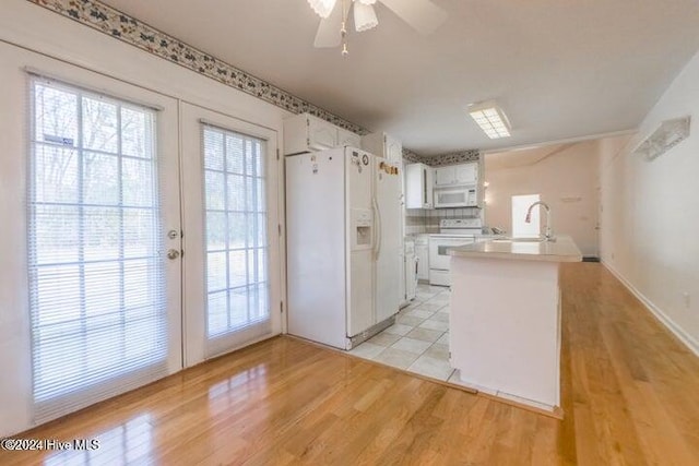 kitchen featuring white appliances, french doors, light hardwood / wood-style floors, decorative backsplash, and white cabinetry