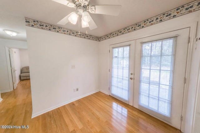 empty room featuring ceiling fan, light hardwood / wood-style flooring, and french doors