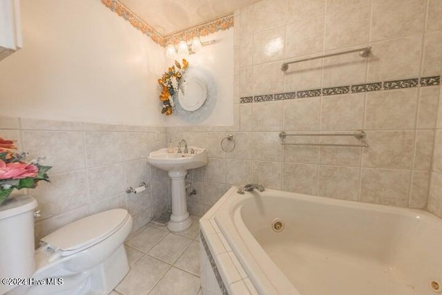 bathroom with tile walls, toilet, a relaxing tiled tub, and tile patterned floors