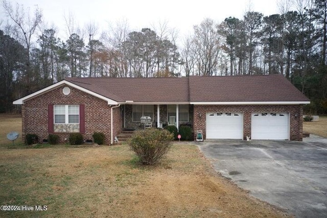 single story home with covered porch, a front lawn, and a garage