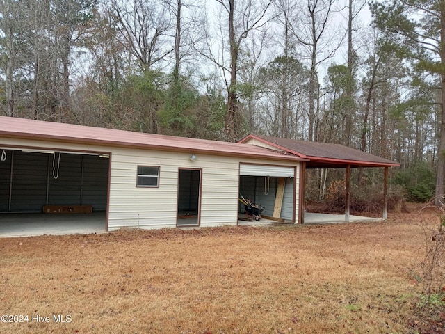 view of outbuilding with a lawn and a carport