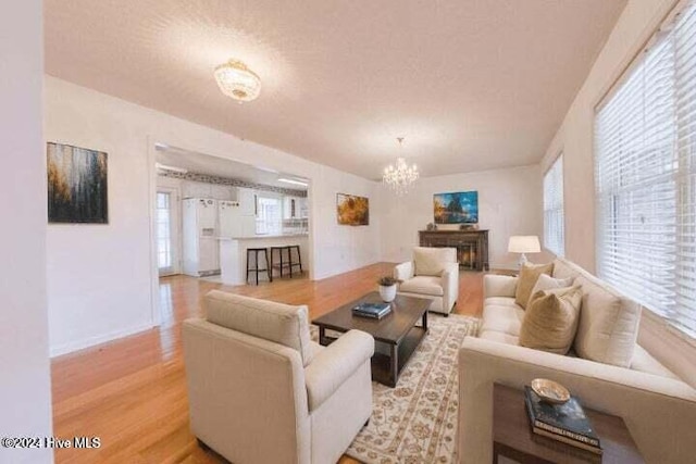 living room with light wood-type flooring and a chandelier