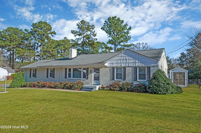 view of front of property with a front yard and a shed