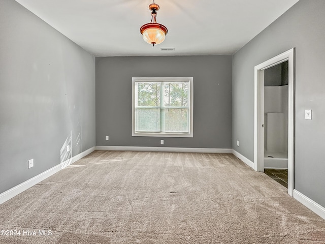 unfurnished room featuring light carpet