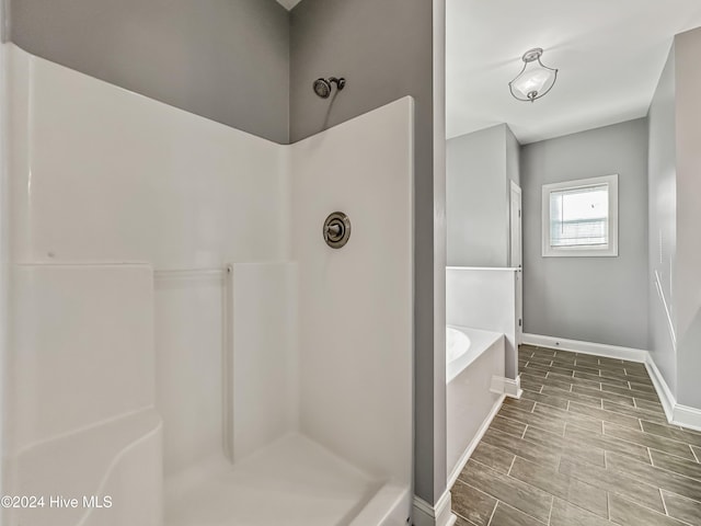 bathroom featuring shower with separate bathtub