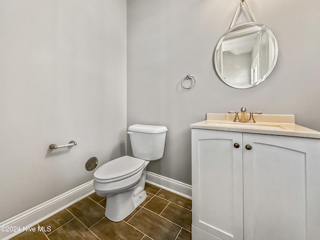 bathroom featuring tile patterned floors, vanity, and toilet