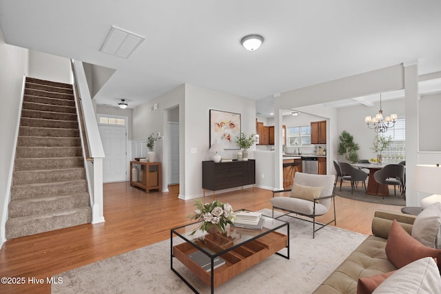 living room with a chandelier and light wood-type flooring