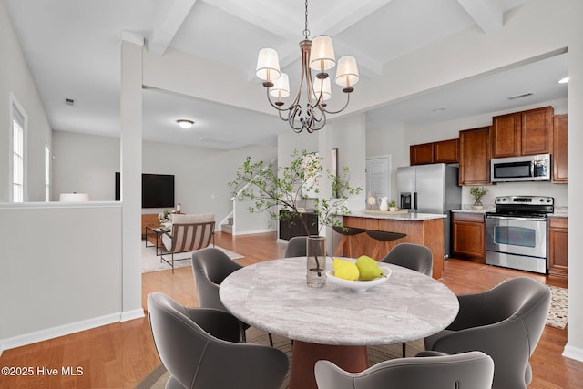 dining room featuring a notable chandelier, beam ceiling, and light hardwood / wood-style flooring