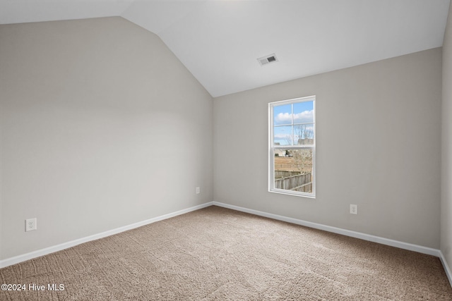 empty room featuring lofted ceiling and carpet