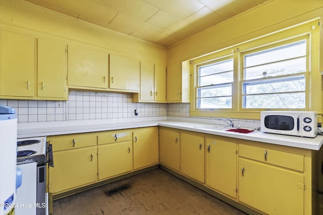 kitchen featuring backsplash, white appliances, and sink