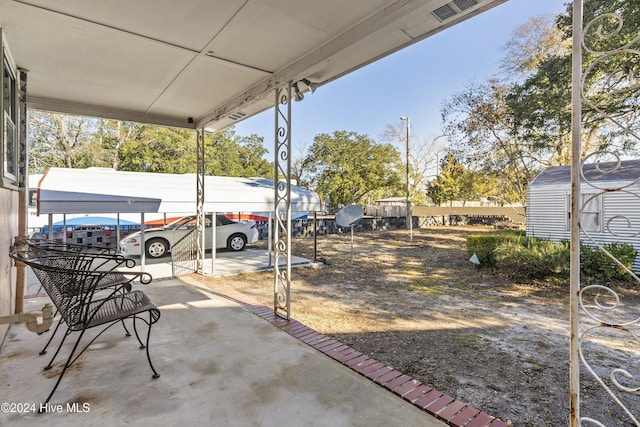 view of patio / terrace featuring a shed and a carport