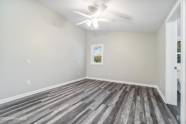 empty room with ceiling fan, dark hardwood / wood-style flooring, and lofted ceiling