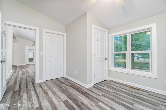 unfurnished bedroom featuring ceiling fan, light hardwood / wood-style flooring, and lofted ceiling