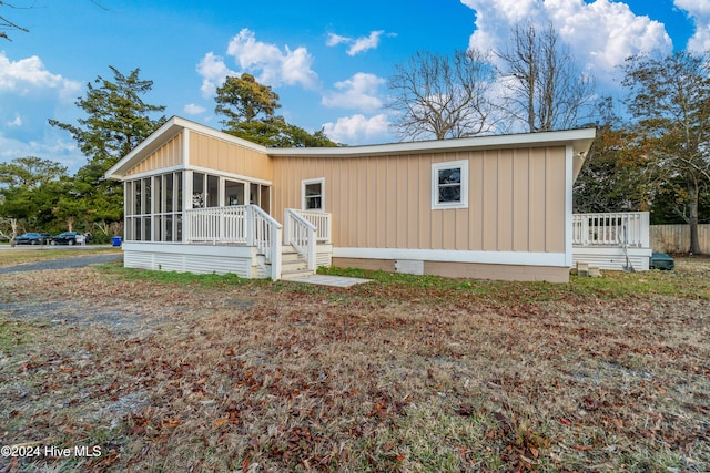 view of front of house featuring a sunroom and a wooden deck