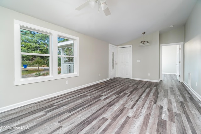 unfurnished room featuring hardwood / wood-style floors, ceiling fan with notable chandelier, and lofted ceiling