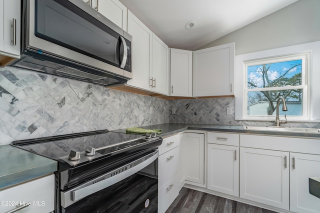 kitchen with white cabinetry, sink, appliances with stainless steel finishes, and vaulted ceiling