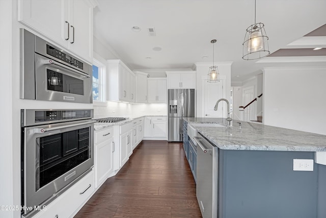 4450 Old Towne St, Wilmington, NC 28412 - kitchen with appliances with stainless steel finishes, light stone countertops, a kitchen island with sink, white cabinetry, and ornamental molding