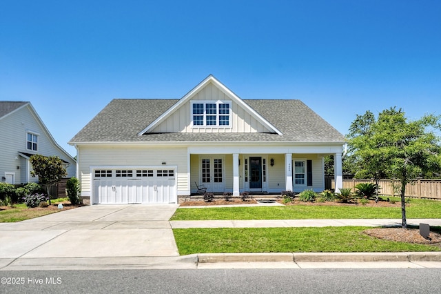4450 Old Towne St, Wilmington, NC 28412 - view of front of house featuring board and batten siding, covered porch, a garage, concrete driveway, and roof with shingles