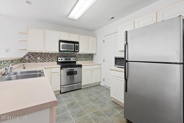 kitchen with appliances with stainless steel finishes, tasteful backsplash, and sink