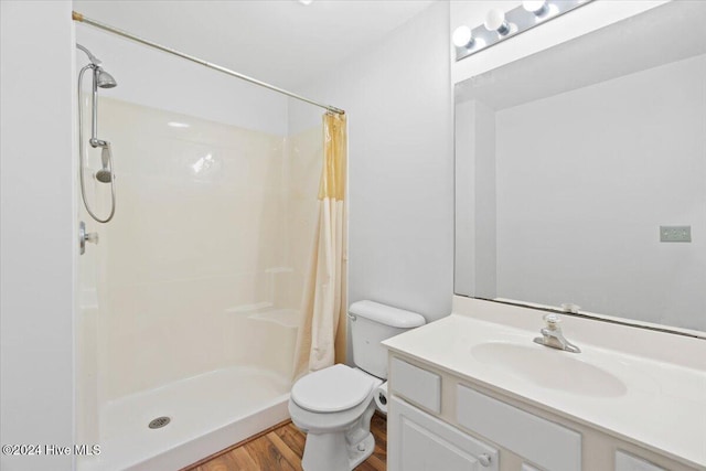 bathroom with vanity, hardwood / wood-style flooring, toilet, and walk in shower