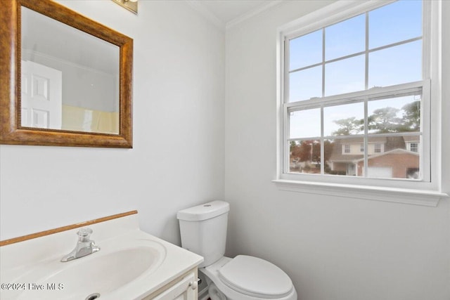 bathroom featuring a wealth of natural light, vanity, ornamental molding, and toilet