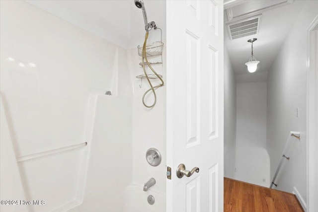 bathroom with wood-type flooring and tub / shower combination