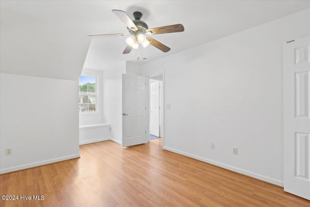 interior space with ceiling fan, vaulted ceiling, and light hardwood / wood-style flooring