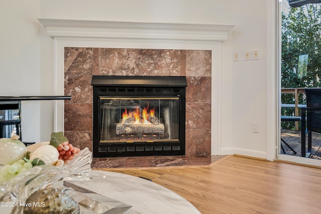 room details featuring hardwood / wood-style flooring and a tiled fireplace