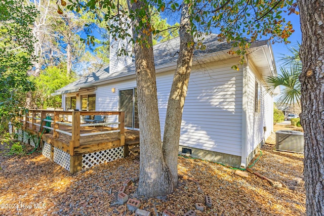 back of property with a wooden deck and central AC