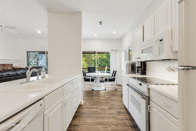 kitchen featuring white cabinets, white appliances, sink, and dark wood-type flooring