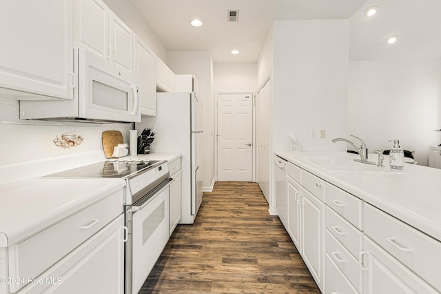 kitchen with tasteful backsplash, white appliances, sink, white cabinets, and dark hardwood / wood-style floors