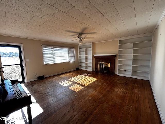 unfurnished living room featuring built in shelves, a fireplace, hardwood / wood-style floors, and plenty of natural light