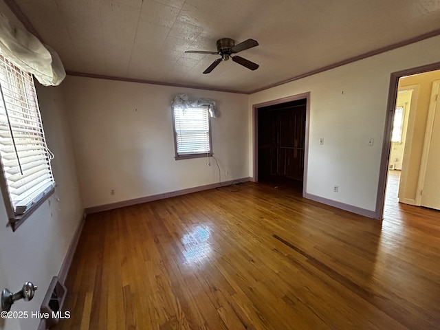 unfurnished bedroom with ceiling fan, a closet, ornamental molding, and hardwood / wood-style flooring