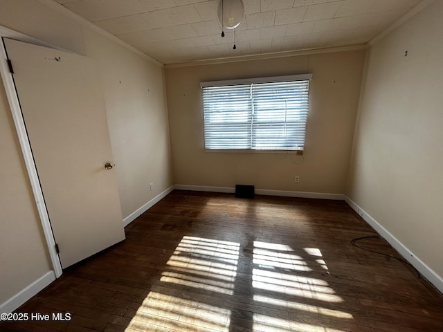 empty room with dark wood-type flooring and crown molding