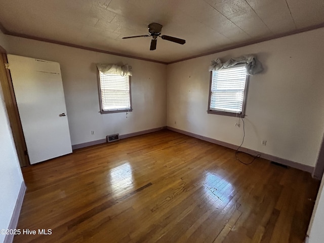 empty room featuring crown molding, hardwood / wood-style floors, and a healthy amount of sunlight